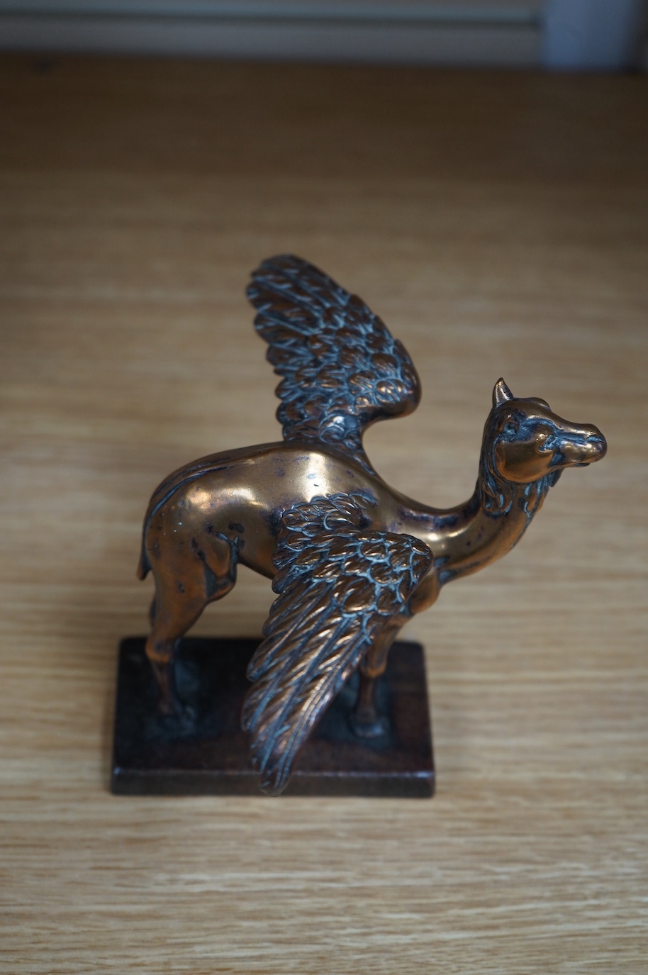 A bronze Royal Air Force 45th Squadron winged camel desk ornament, stamped Reg.746774 to the base
